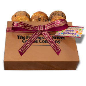 Gold Gift Box of cookies with a Famous 4th St burgundy ribbon tied around it and affixed with a tag reading Happy Birthday