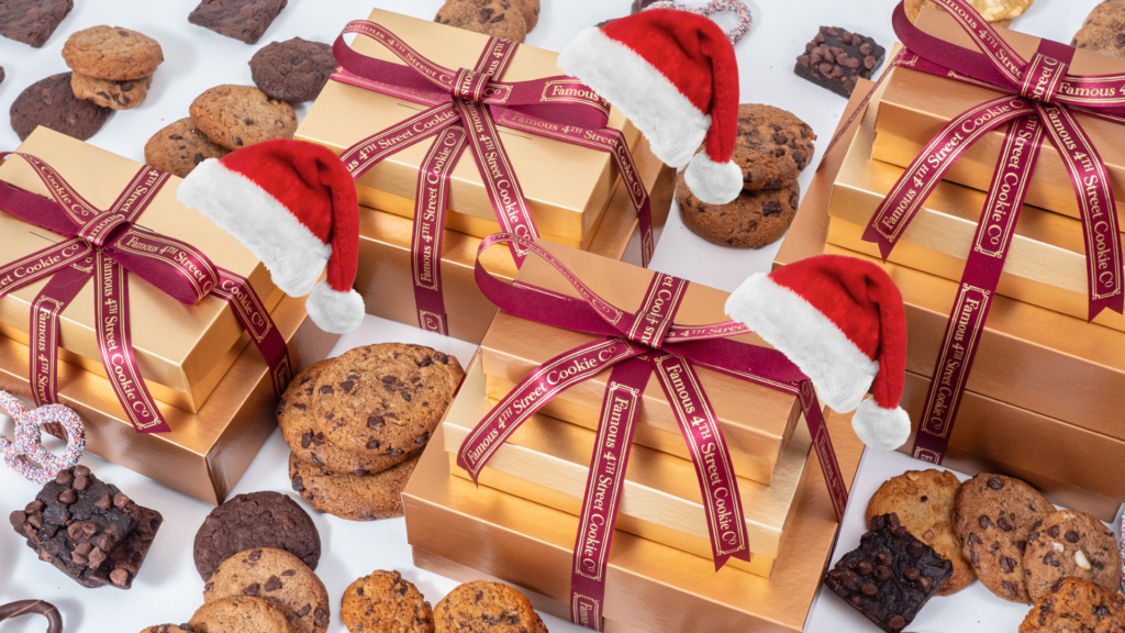 Stacks of Famous 4th St. Gift Towers with santa hats, chocolate chip cookies, brownies, pretzels, and mini oatmeal raisin cookies.
